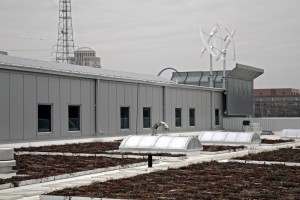 A rooftop photo of the wind turbines and other solar-powered structures for the building.