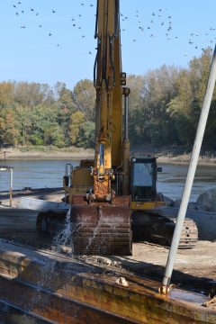 A backhoe lifts heavy boulders to prevent a scour at the abutment of the Highway 54 Missouri River Bridge Oct. 22, 2015 near Jefferson City. (Travis Zimpfer/The Missouri Times)