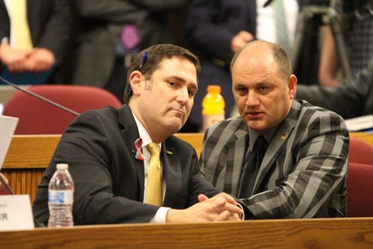 Rep. Mike Colona speaks with Rep. Denny Hoskins during the SJR 39 hearing (Tim Curtis/The Missouri Times)